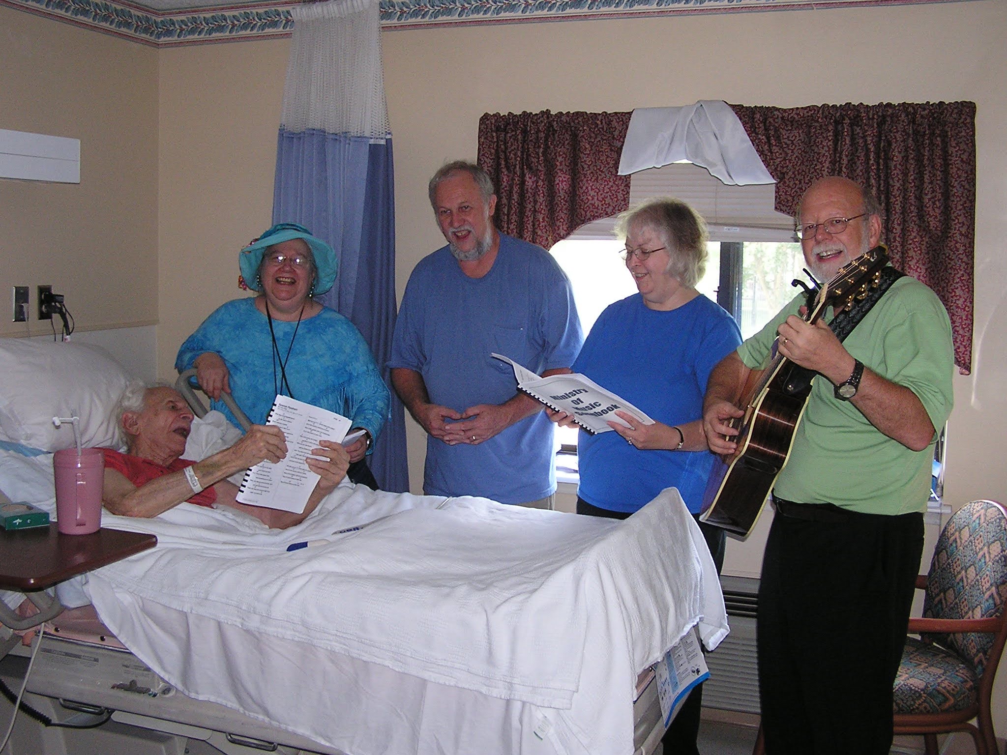 Chuck Howe (in bed) sings with MOM participants Alice Zawadzki, Billy Liles, Cathy Murphy and Tom Atkinson; summer 2010.