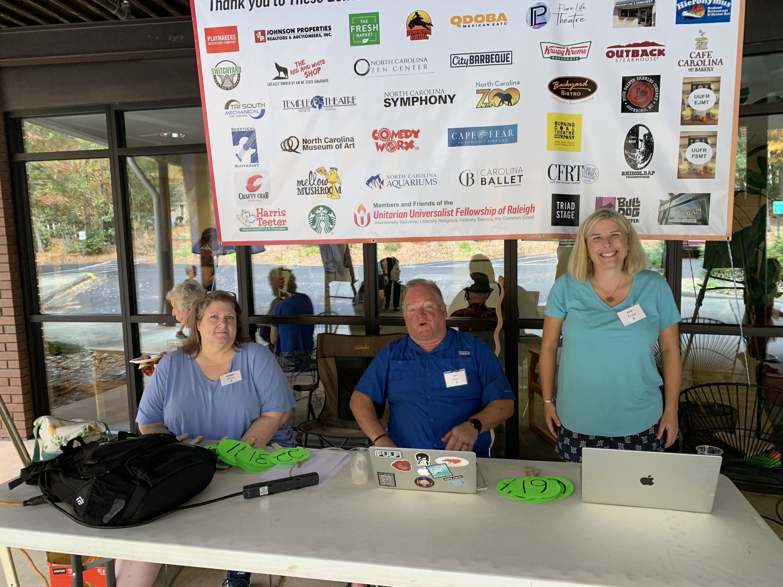 Maggie Inman, Kurt Johnson and Erin Krupa provide paddle service as auction bidders arrive.